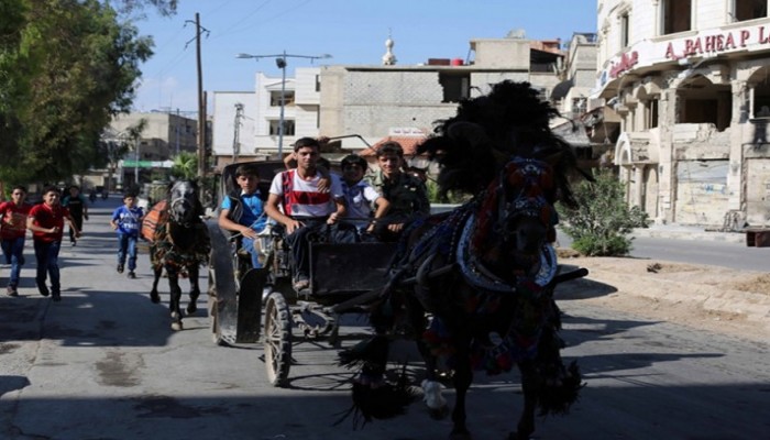 أطفال غوطة دمشق المحاصرة يبحثون عن أحلامهم بين أراجيح العيد