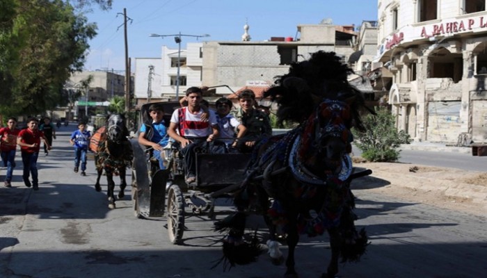 أطفال غوطة دمشق المحاصرة يبحثون عن أحلامهم بين أراجيح العيد