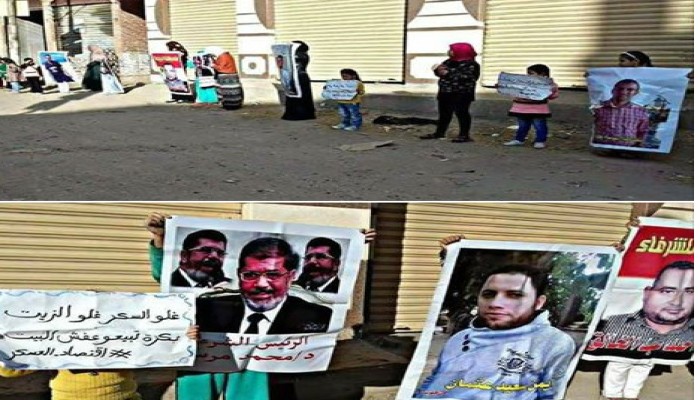 أبناء المعتقلين بمنيا القمح يتظاهرون بصور ذويهم