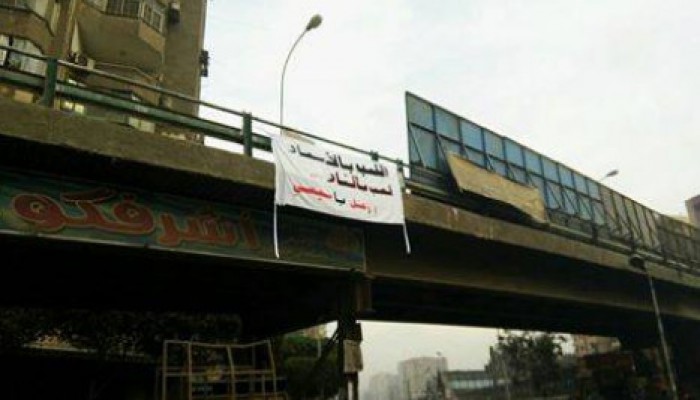 شباب ضد الانقلاب يعلقون لافتة ضخمة أعلى كوبري بالزيتون