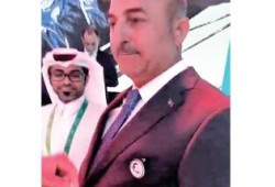 وزير خارجية تركيا يضع صورة "تميم المجد" على صدره في مؤتمر دولي