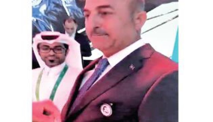 وزير خارجية تركيا يضع صورة "تميم المجد" على صدره في مؤتمر دولي
