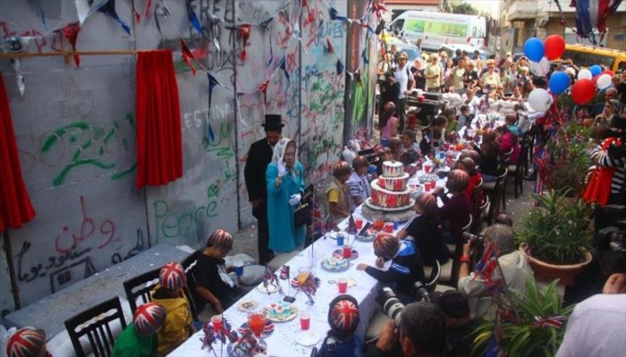 مشهد تمثيلي قرب جدار الفصل.. "بريطانيا تعتذر" للشعب الفلسطيني