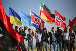 فلسطينيون يرفعون أعلام دول عربية وأوروبية على حدود غزة
