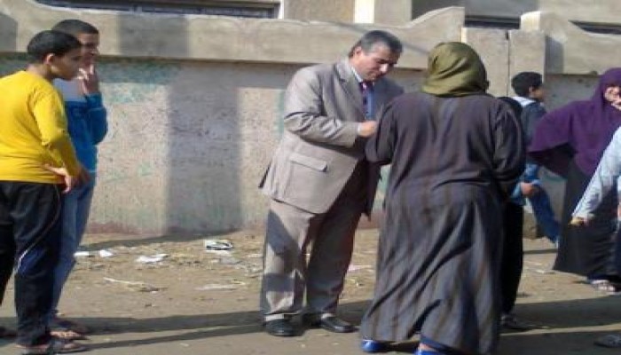 مرشح يرسم رمزه الانتخابى على أيدي السيدات بالدقهلية
