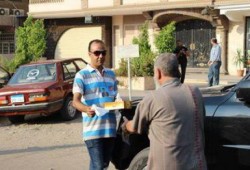 (صورة وتعليق) كان يمر بسيارته فوقف ليقوم بتوزيع مناديل علي الداخلين للاعتصام