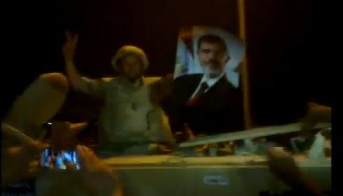 بالفيديو جندى مصرى يرفع صورة الرئيس مرسى على مدرعه أمام مدينة الانتاج أمس