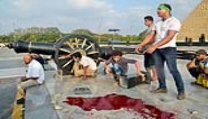 مسيرة تحمل أكاليل الزهور لوضعها بموقع استشهاد مجزرة النصب التذكاري