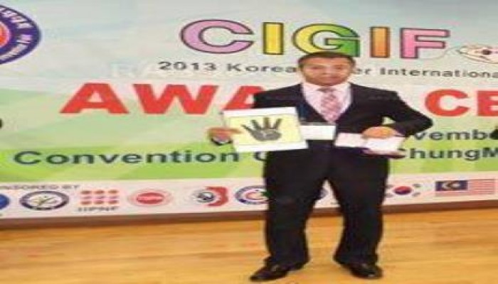 مهندس مصري يرفع شعار رابعة اثناء تكريمه بكوريا الجنوبية