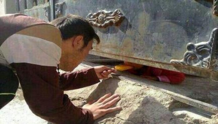 شاب سوري يُطعم طفلة من تحت باب منزلها لطمأنتها بعد القصف