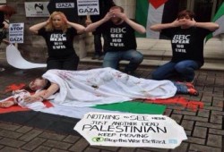 نشطاء أوربيين يقدمون مشهد تمثيلي ينتقد انحياز"بي بي سي" للإحتلال الصهيوني أمام مقر الوكالة