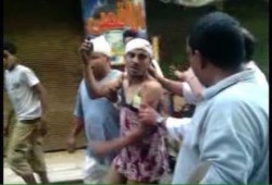 بالصور..ثوار العمرانية يجعلون بلطجي يلبس "قميص نوم" في الشارع بعد اعتدائه على مسيرة للنساء