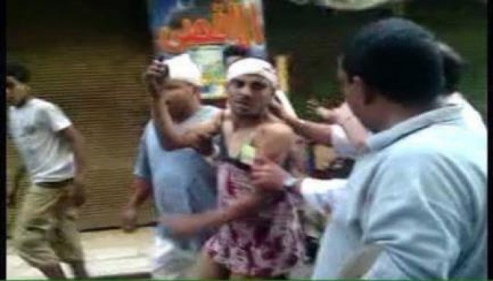 بالصور..ثوار العمرانية يجعلون بلطجي يلبس "قميص نوم" في الشارع بعد اعتدائه على مسيرة للنساء