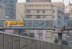 شباب يضعون لافتة منددة بمذبحة رابعة بجوار قسم شرطة بالإسكندرية