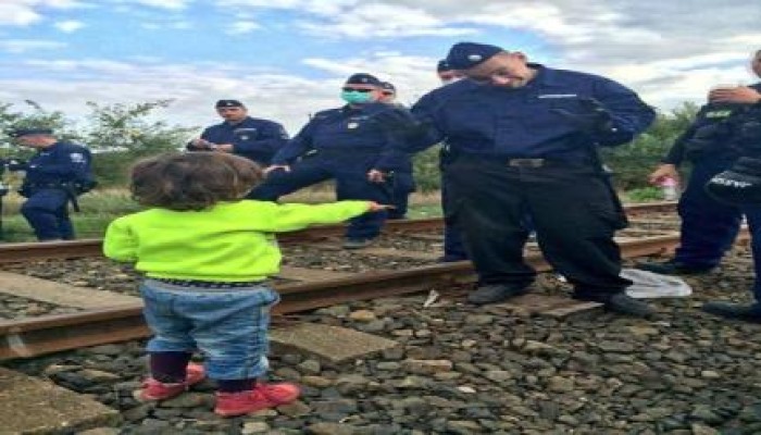 طفل سوري لاجئ يعطي الحلوى للشرطة المجرية لكي تسمح له بالعبور