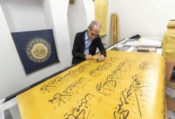 صور || في 6 سنوات.. عراقي يخط أكبر مصحف بالعالم